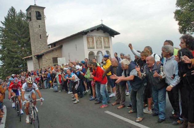 Bettini leads the breakaway group as they pass a church. Photo copyright Fotoreporter Sirotti.