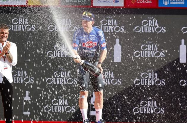 Kaden Groves celebrates his stage victory with champagne on the podium