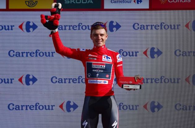 Remco Evenepoel on the podium wearing the Vuelta a Espana leader jersey