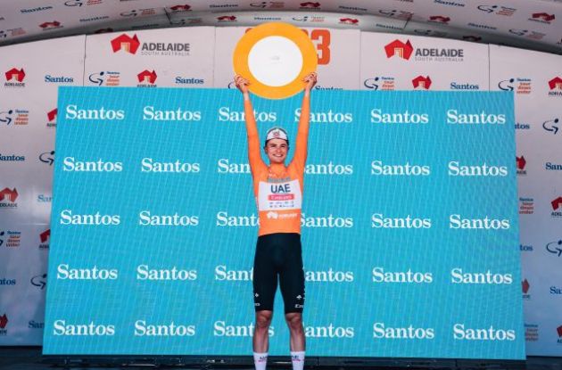 Jay Vine lifts his winner trophy above his head on the 2023 Tour Down Under podium