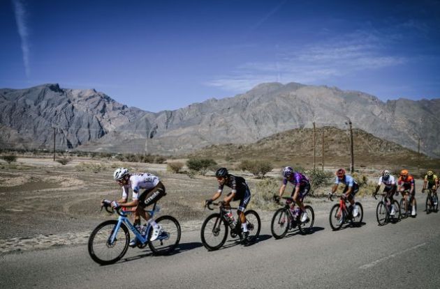 Cycling peloton with Oman mountains