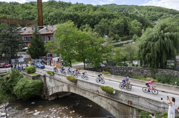 | Unipublic Cyclists crossing old bridge during Vuelta a Espana