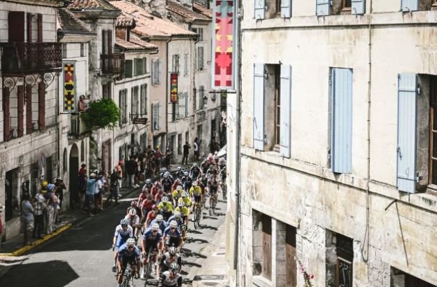 Cyclists ride through French village