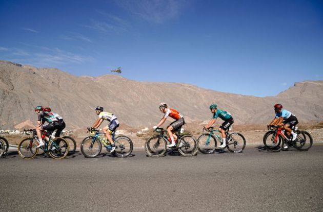 Cycling peloton riding through Oman desert 