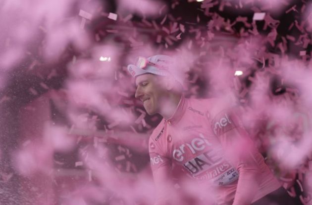 Tadej Pogacar wearing pink jersey celebrating with champagne on Giro d'Italia podium