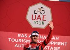 Remco Evenepoel on the podium wearing the UAE Tour leader jersey