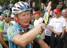 Alexander Vinokourov of Kazakhstan, who was sacked from the Astana team after he tested positive for blood doping in the 2007 Tour de France, waves to supporters as he returns to cycling after a two-year doping ban at Castillon la Bataille, August 4, 2009. Reuters.