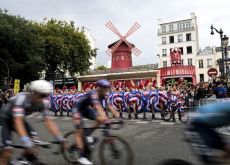 | A.S.O. Tour de France cyclists passing cancan Doriss girls near Moulin Rouge