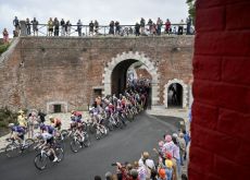 Cyclists passing under citadel wall