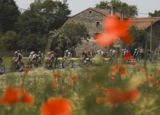 | A.S.O. Cyclists passing poppy field and French village