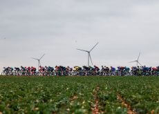 Cyclists pass windmills in France