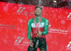 Filippo Ganna with champagne on the podium as winner of stage 14 of Giro d'Italia 2024 for Ineos-Grenadiers