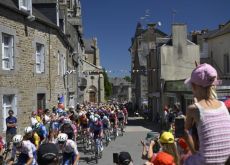 | A.S.O. Pro cyclists race through Bretagne village during stage 7